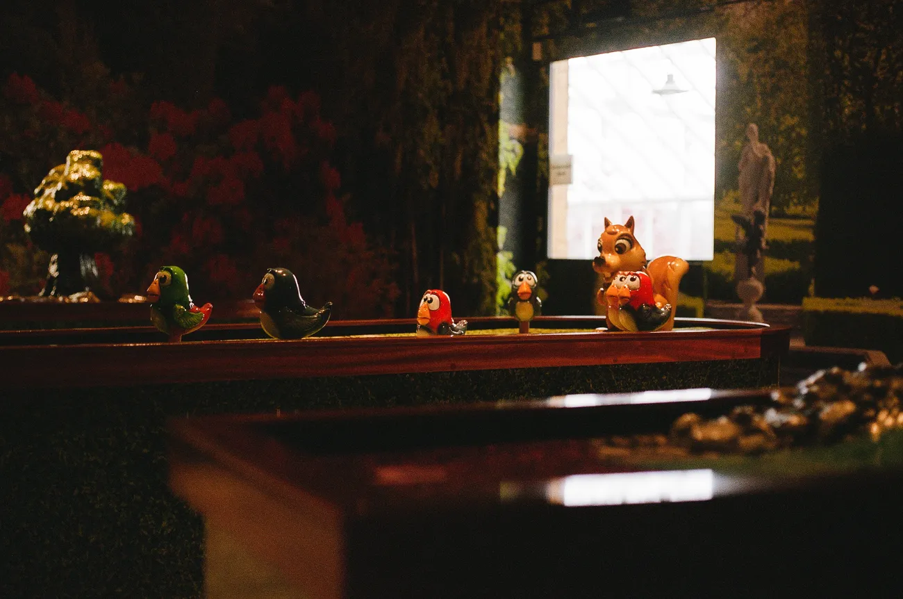Handmade bird and squirrel props on a Cue Golf table