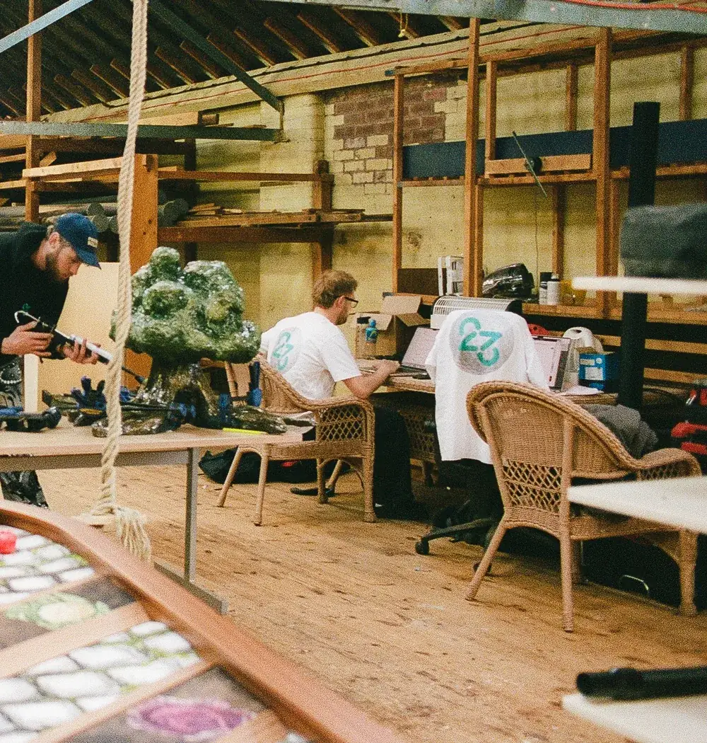 Designing at the desks while a tree prop takes shape in the workshop
